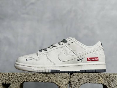 放店私 Supreme X Nike Dunk Low 白灰双拼 此款主张打破传统的工业化流水线设计限制，以made By Ideas的超级创意为理念，集结众多